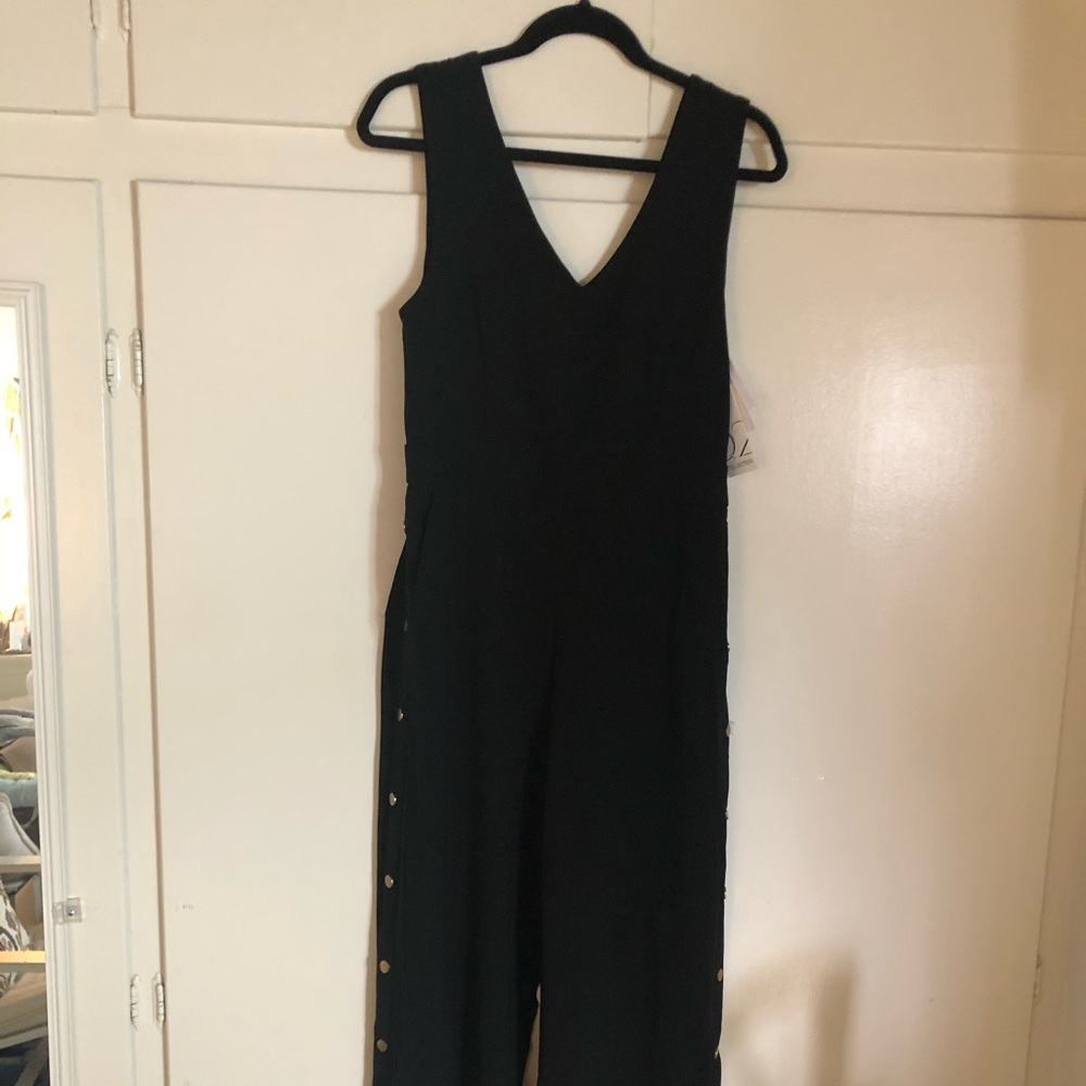 Adorable black jumpsuit with gold tone buttons.